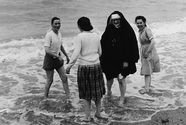 A Roman Catholic nun and three other women wade in the surf at the seaside, 1950s. (Photo by Express Newspapers/Getty Images)